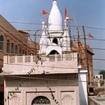 Sri Chaitanya Saraswat Math stands adjacent to the compound wall (visible on the right) of the Sri Sri Radha Damodar Temple